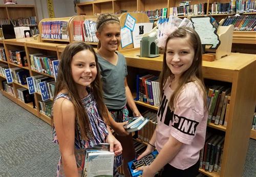 three middle school students in library 